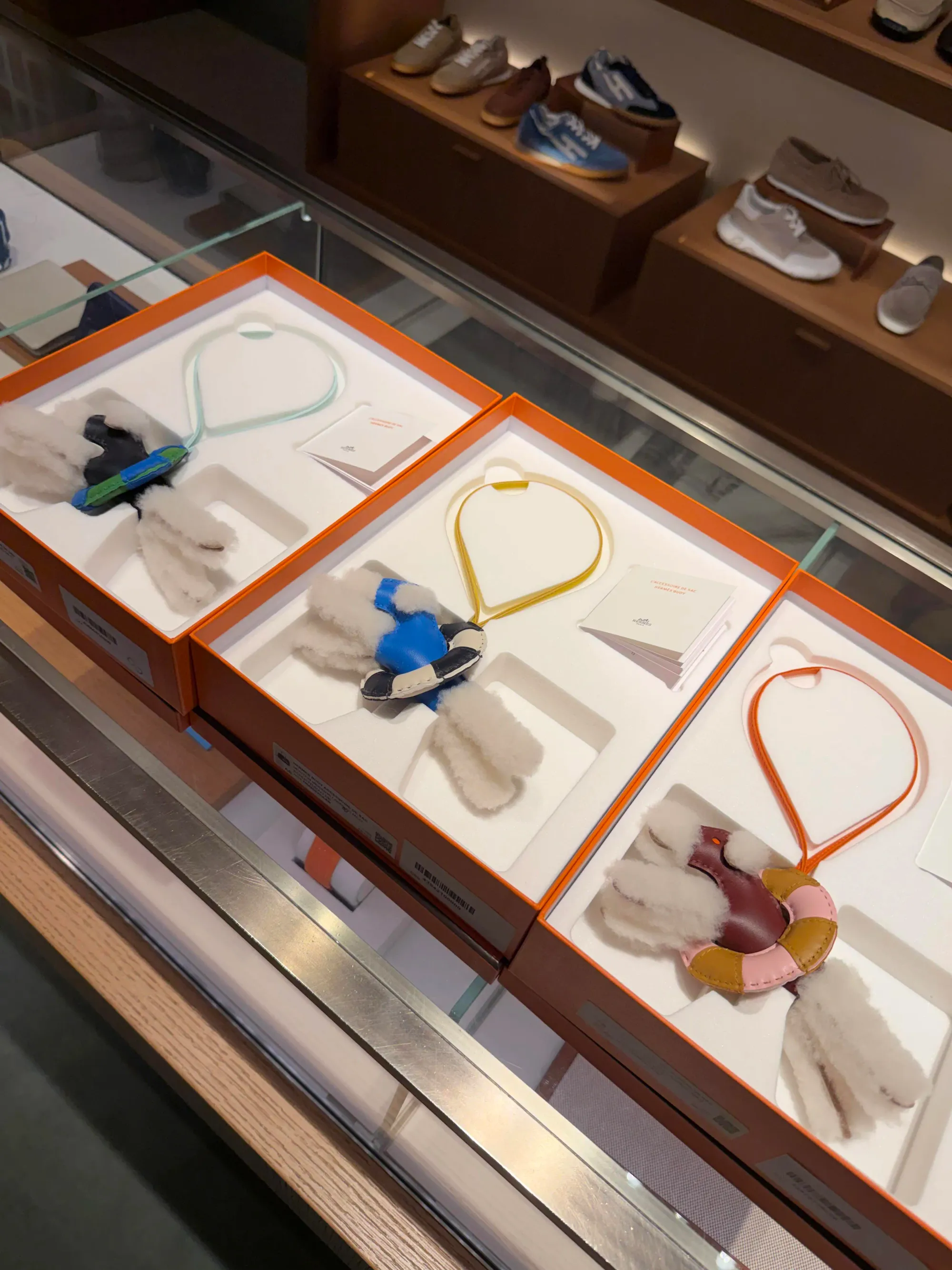 網民分享3款白色Merinos羊毛Fox Terrier版本嘅Hermès Budy「À la Mer」Charm實物。三款均採用Écru白色毛絨設計，分別配搭不同顏色上衣、救生圈及皮革掛繩，可更清楚比較各款配色組合及毛絨材質質感。