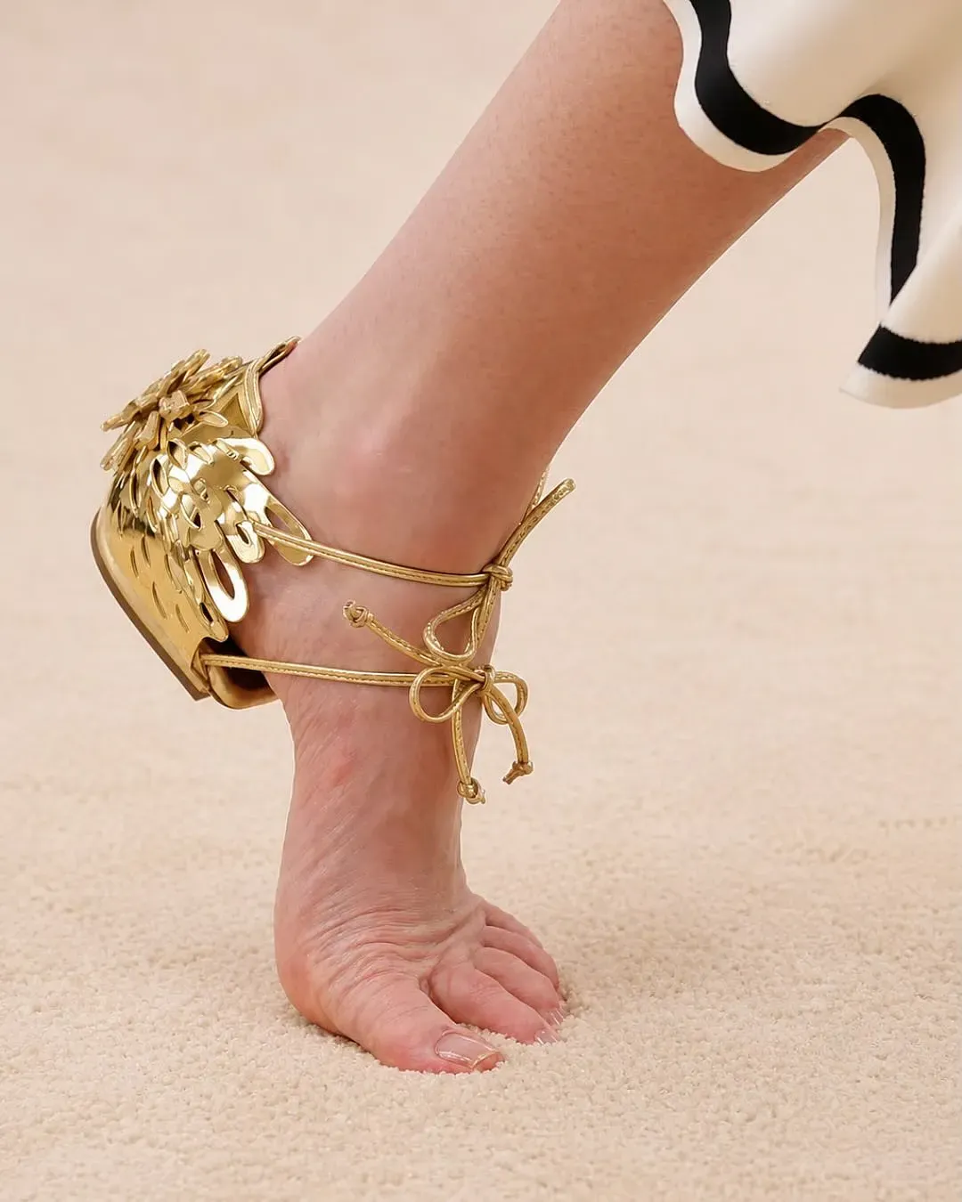 CHANEL Cruise 2026/27 系列出現一款極具話題性嘅鞋履設計,鞋底結構大幅簡化,視覺上近似赤腳行走,再以鞋跟及綁帶等元素呈現。有網民將呢類設計戲稱為「無底鞋」,亦成為討論 Matthieu Blazy 設計風格時嘅例子。