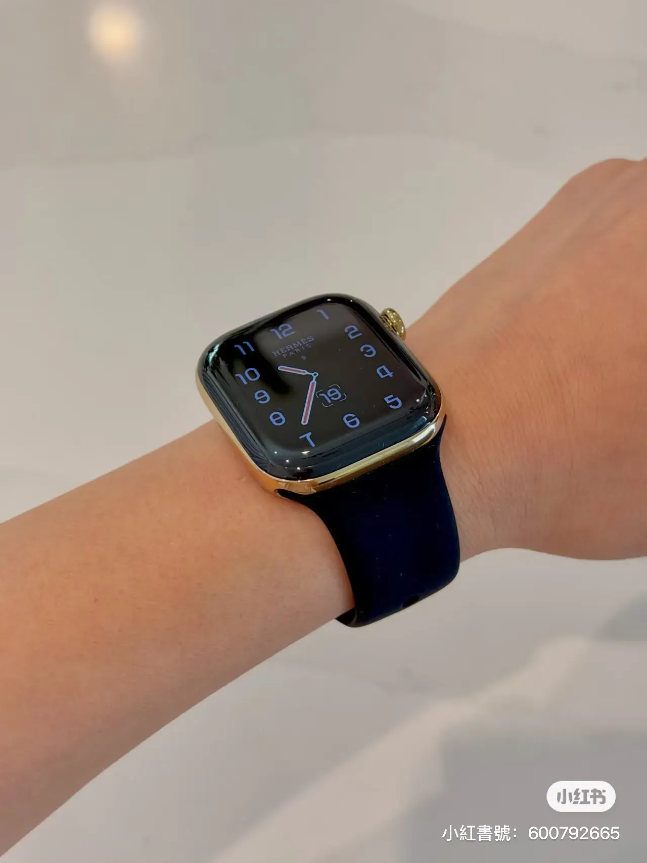 Apple Watch Hermès Series 12耀金色實物,配搭 黑色 Sport Band 嘅上手效果,可見耀金色錶殼與黑色錶帶形成鮮明對比。
