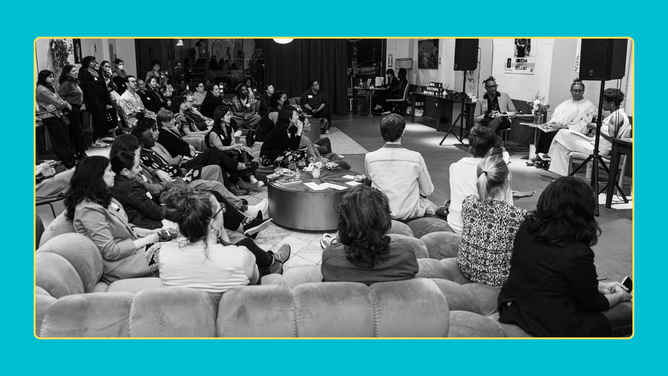 Photo Credit: Bethanie Hines - Black and white photo of Next River's event, with three speakers on the r and the crowd seated watching.