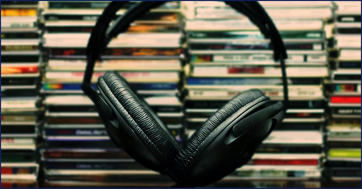 headphones in the foreground in front of CDs
