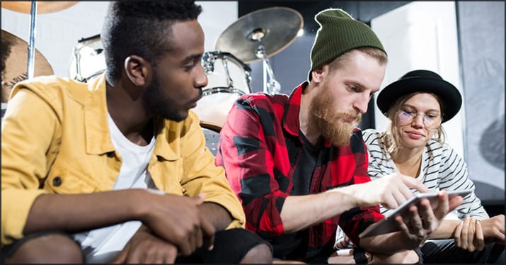 band working on music sales in their rehearsal space
