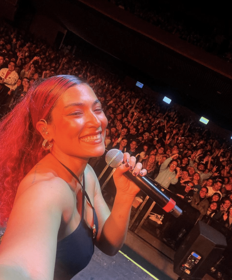 A woman conducting a case study, holding a microphone in front of a crowd.