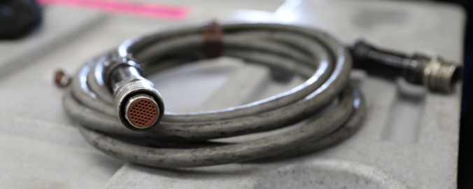 A picture of a silver 14-channel multi-pin snake connector is portrayed 