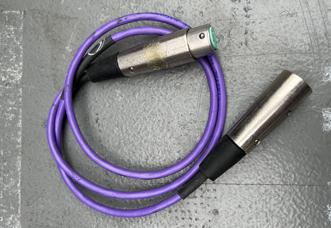 A picture of a purple AES cable on a grey background is portrayed 