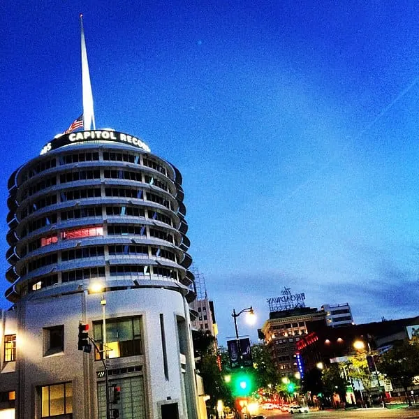Capitol Records Building in Los Angeles at dusk, iconic music industry landmark with vibrant city lights and skyline backgrou
