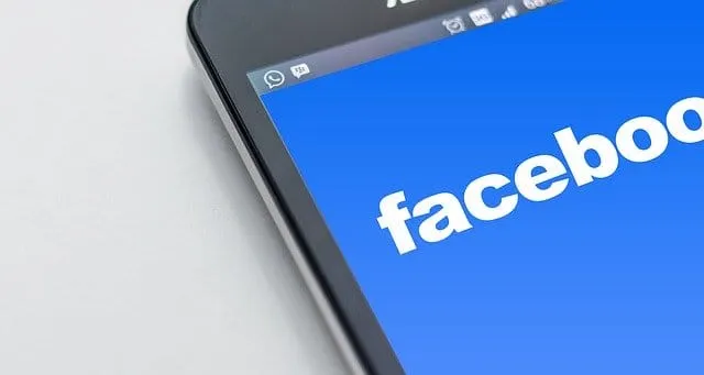 Facebook logo displayed on a smartphone screen, representing social media marketing and digital communication.
