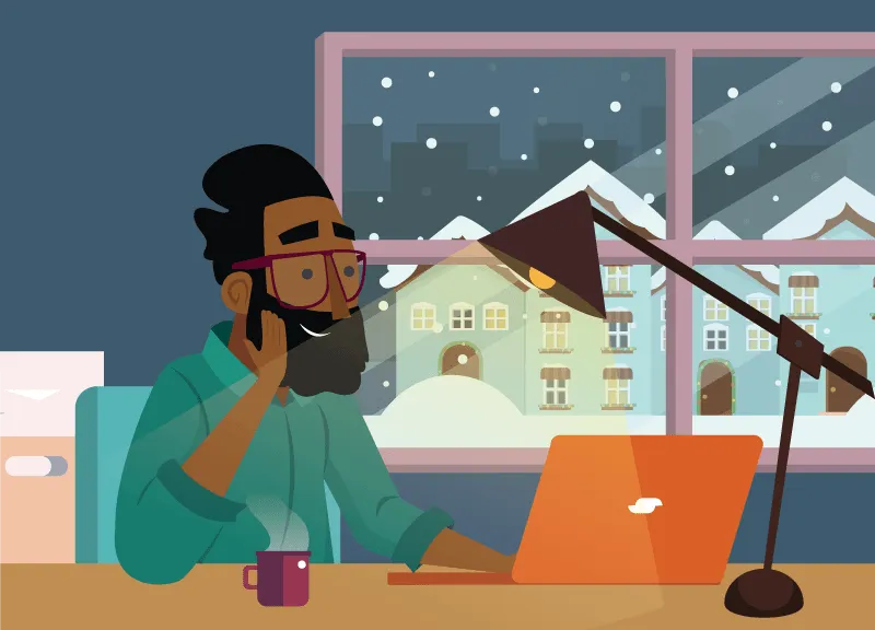 Cozy home office workspace with a person working on a laptop during winter snowstorm, featuring warm lighting, a desk lamp, a