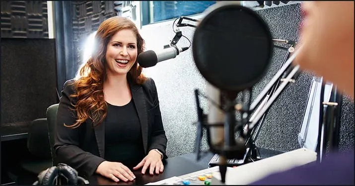 Recording a podcast interview with a female host in a professional radio studio for music, media, and entertainment industry