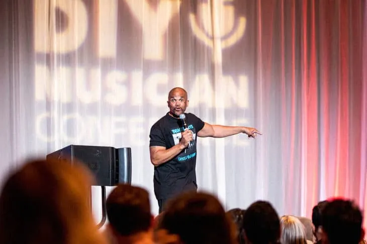 Innovative speaker at music industry conference presenting to engaged audience.