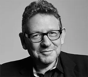 A professional black-and-white portrait of a man wearing glasses, dressed in a suit, smiling confidently. Suitable for articl