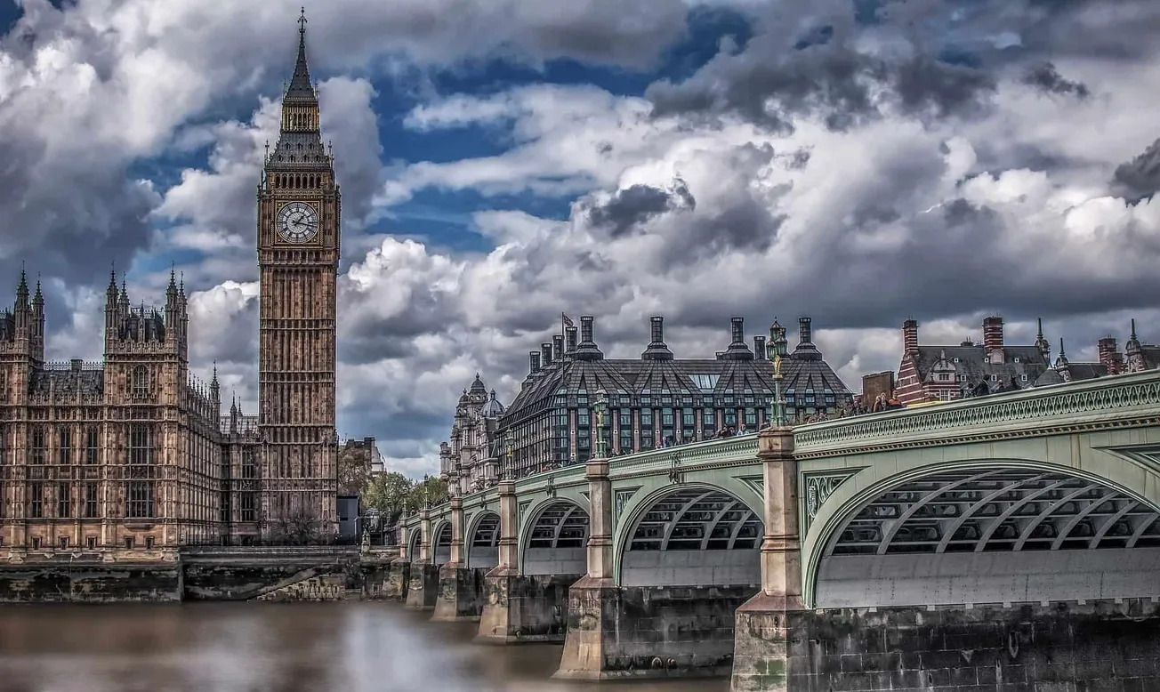 London Big Ben clock tower and Westminster Bridge over the Thames River under dramatic cloudy sky, iconic UK landmarks, histo