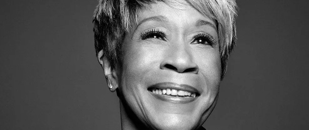 Smiling mature woman with short hair, expressing happiness, black and white portrait.