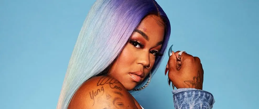 Rainbow-colored long straight hair with pastel shades, woman with tattoos and jewelry modeling for Hypebot, vibrant music and