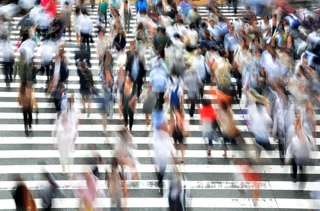 Crowded pedestrian crosswalk in an urban setting, symbolizing busy city life and foot traffic.
