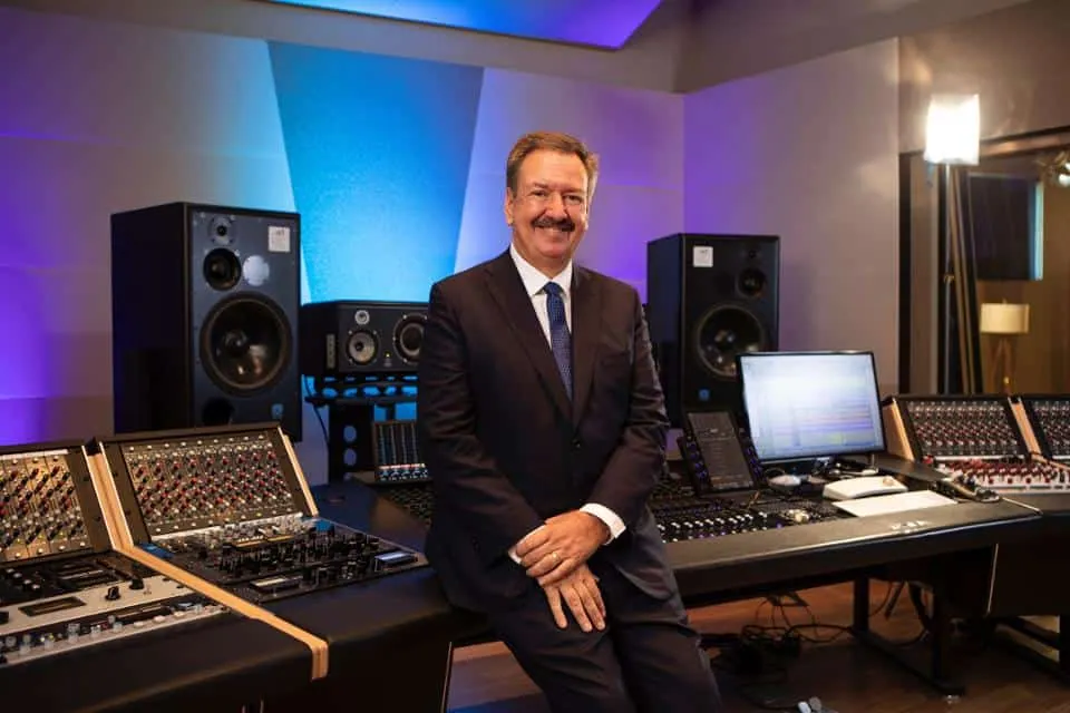 Studio audio engineer in professional recording studio with mixing console, speakers, and music production equipment for musi