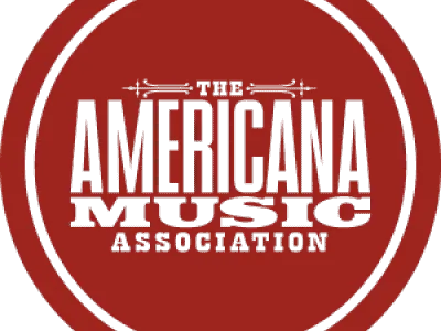 A vibrant red circular logo for the Americana Music Association featuring bold text.