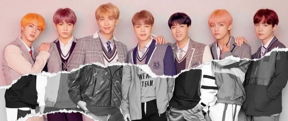 K-pop boy band members in stylish school uniform-inspired outfits, posing together for a photo representing modern music cult