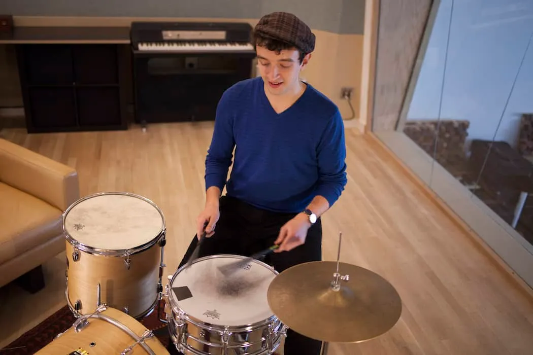 Dynamic young man playing drums in studio, music production, band practice, musician, contemporary music, creative hobby, rec