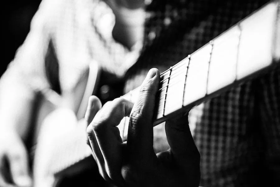Guitarist playing an acoustic guitar close-up, black and white, music performance, musician, guitar music, skillful playing,