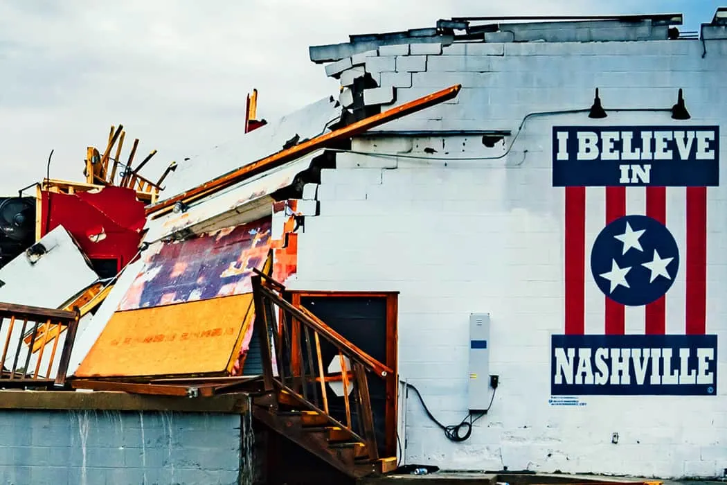 Lively Nashville mural with the phrase "I BELIEVE IN NASHVILLE" painted on a damaged building exterior, featuring patriotic r