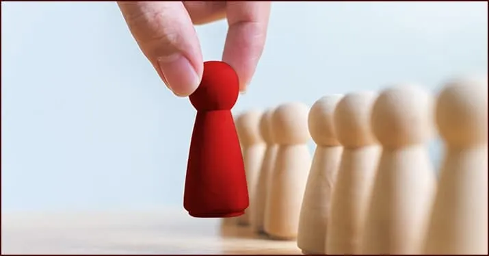 Red pawn chess piece standing out among beige pawns on a chessboard, symbolizing leadership and strategy.