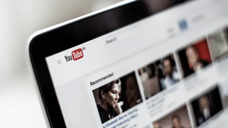 A person browsing YouTube homepage on a laptop screen, with a focus on recommended videos and content discovery in digital me
