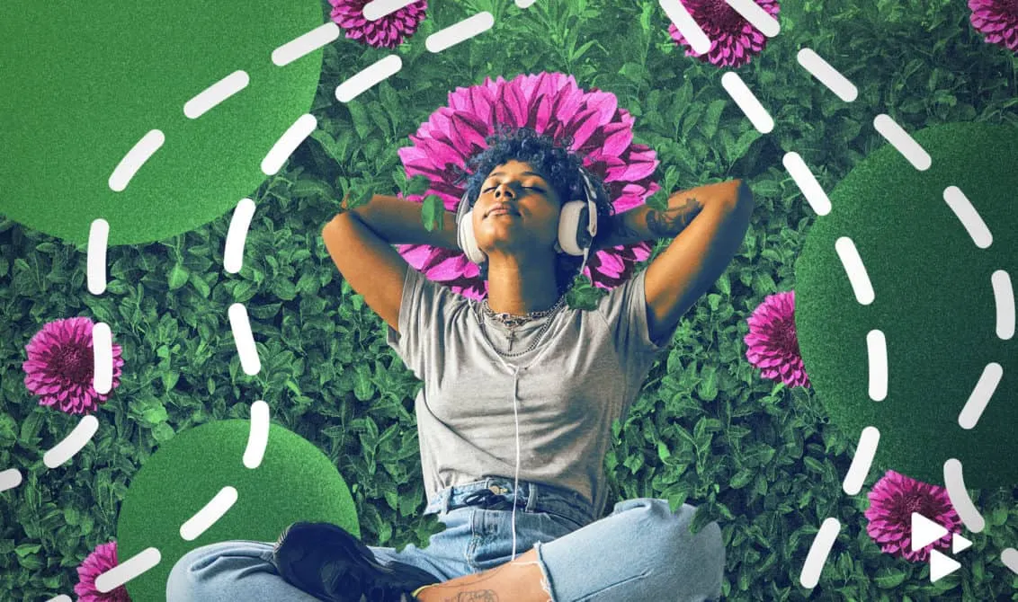 Vibrant woman relaxing with headphones in a garden filled with pink flowers and green foliage, enjoying music outdoors with a