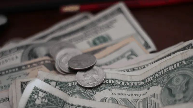 Stacks of US dollar bills and coins, representing earnings, revenue, or financial growth in the music industry and digital me