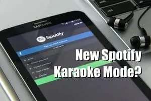 Spotify karaoke mode app on smartphone screen with headphones and music equipment, promoting new features for music lovers.