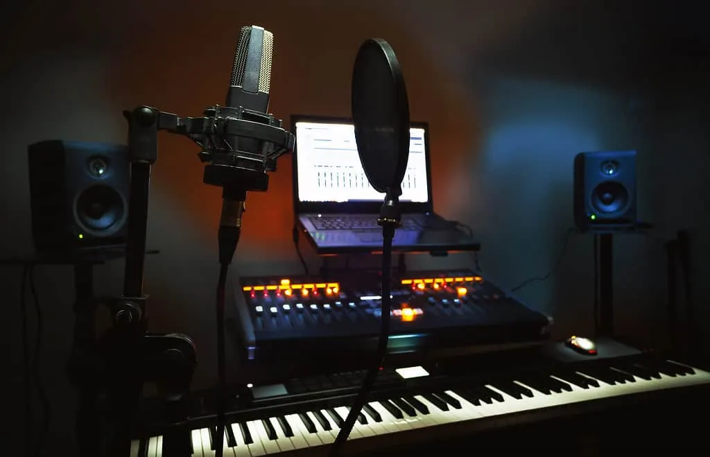 High-quality music studio setup with microphone, keyboard, speakers, and mixing console for professional music production and