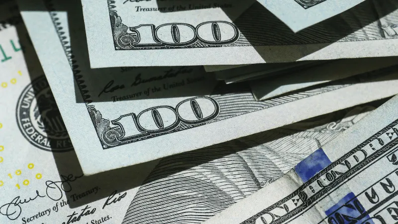 Stacks of hundred-dollar bills representing financial success and revenue generation in the music industry.