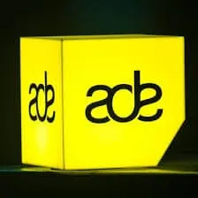 Abc music industry sign illuminated yellow at night.