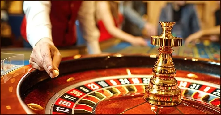 Golden chess piece on casino roulette table; gambling, casino games, and betting strategies; luxury and high-stakes gaming en