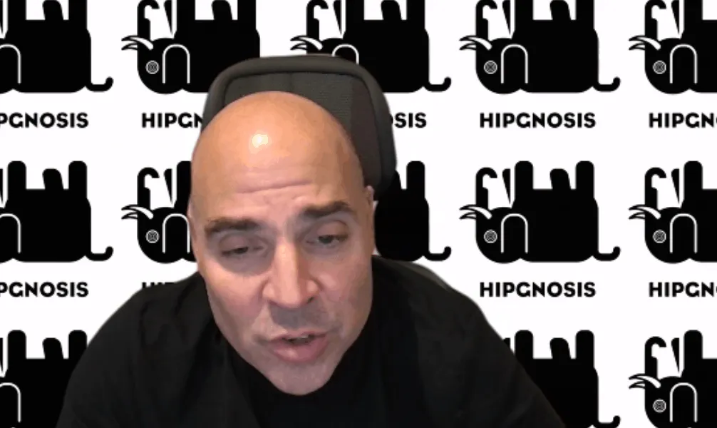 Hipgnosis logo background with man speaking at Hipgnosis company event or interview, music industry branding and entertainmen