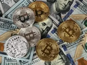 Gold and silver Bitcoin coins on US dollar bills, cryptocurrency, digital currency, blockchain technology, financial investme