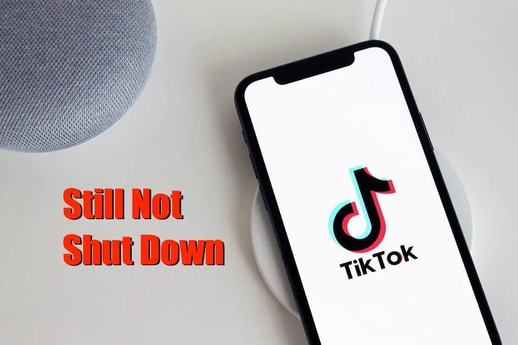 TikTok app on smartphone with wireless charger on white table, emphasizing ongoing social media activity and digital content