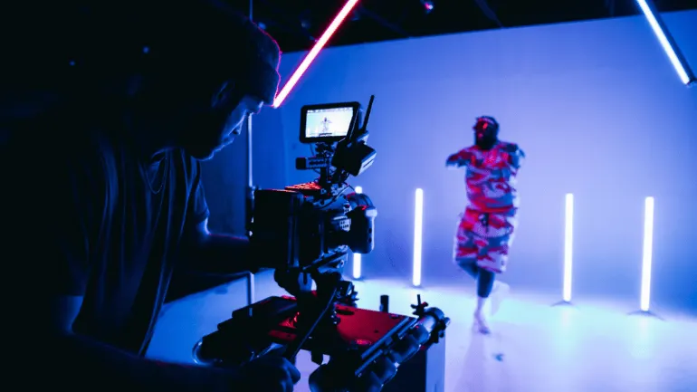Behind-the-scenes videography setup capturing a music video with vibrant neon lighting for an innovative music production by