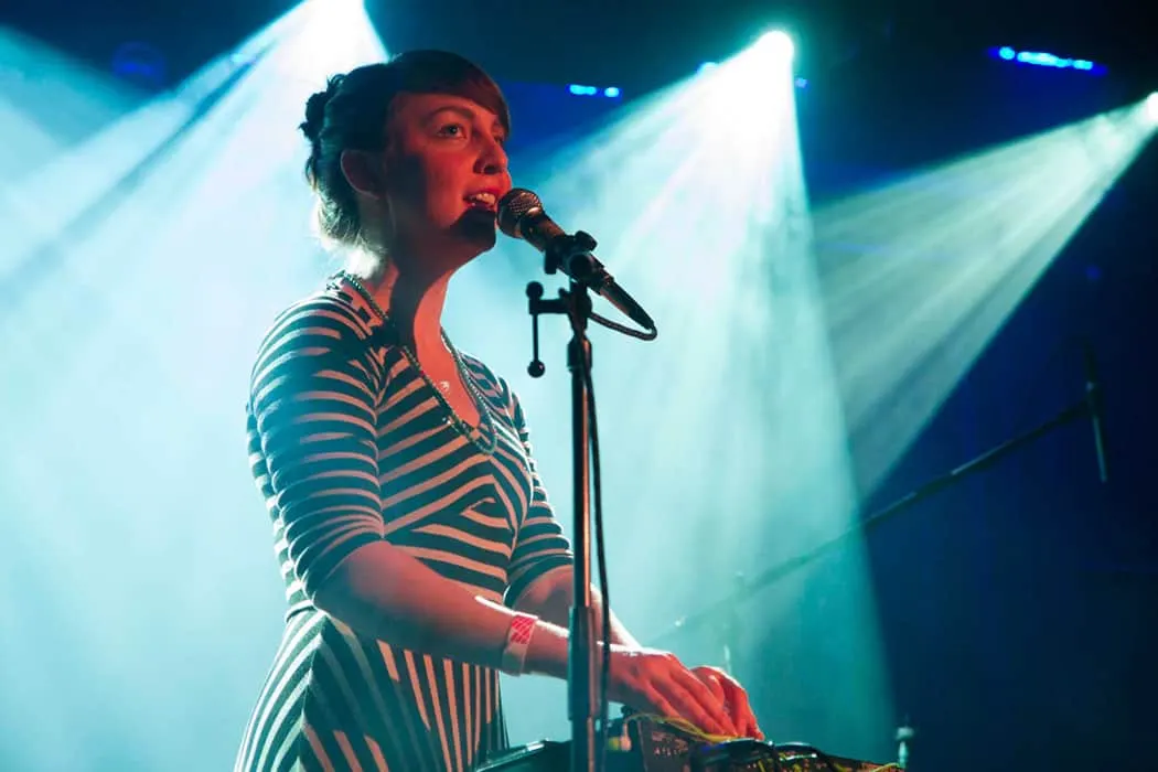 Woman musician performing at concert with microphone and electronic equipment Hypebot music industry event live performance p