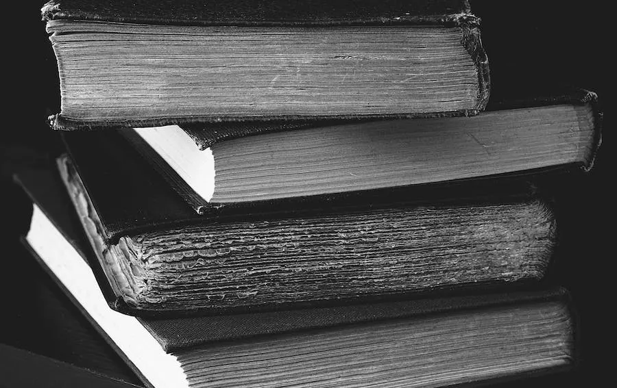 Old worn books stacked together in black and white, illustrating vintage literature or historical texts.