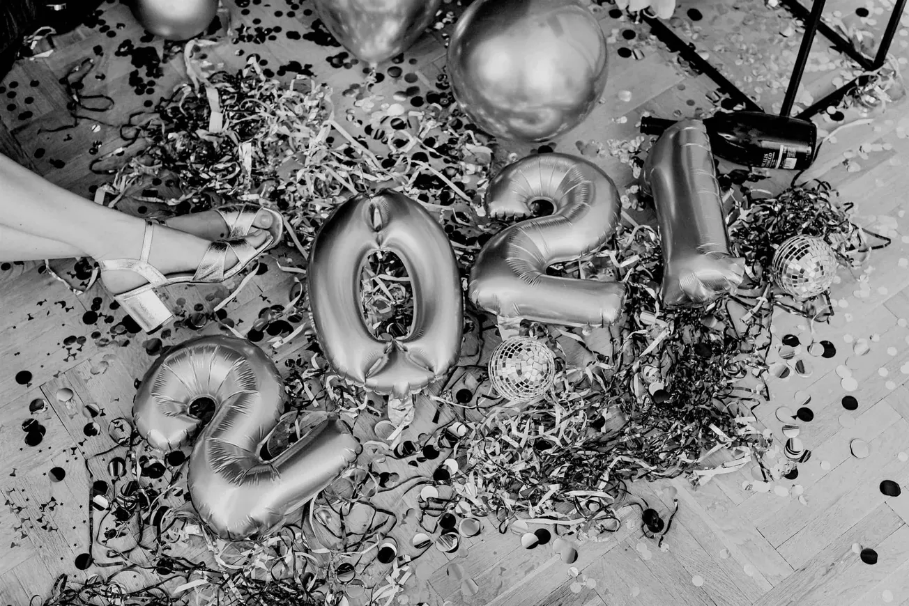 Balloons, confetti, and streamers on a party floor celebrating New Year 2024 with metallic number balloons and decorations, f