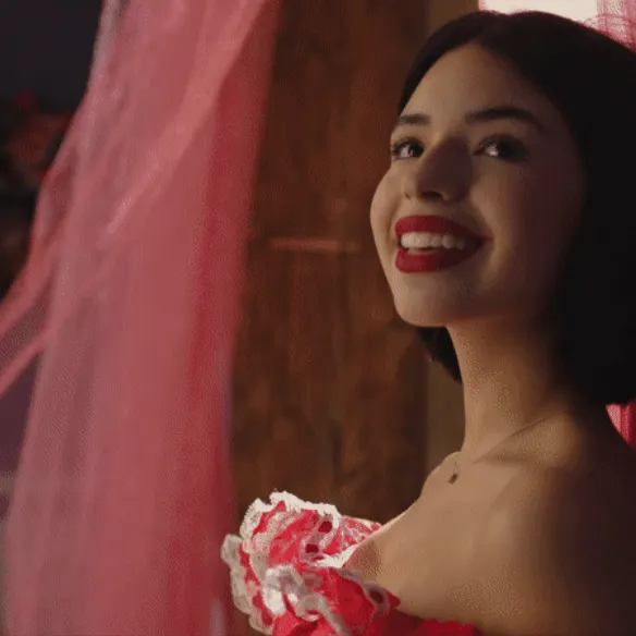 Smiling woman with red lipstick and lace top in a cozy indoor setting, showcasing lifestyle and fashion photography for SEO o