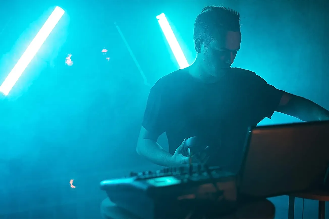 Futuristic DJ performing live with vibrant blue neon lights, blending electronic music and digital DJ culture, ideal for musi