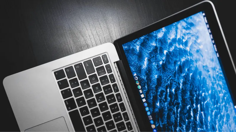 Close-up of a laptop with a digital ocean wallpaper on the screen, showcasing technology and digital innovation.
