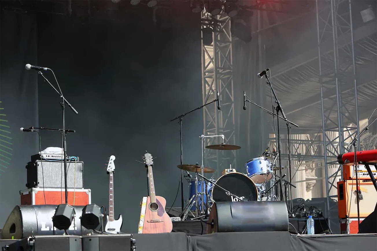 Empty music stage with microphones, guitars, drums, and amplifiers at a live concert or festival. Perfect for articles on liv