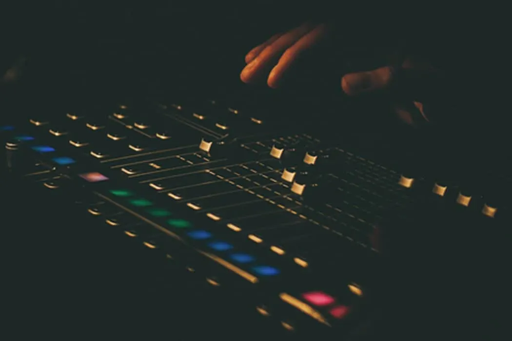 DJ mixing console with illuminated controls and colorful LED lights, close-up shot for electronic music production and DJ per