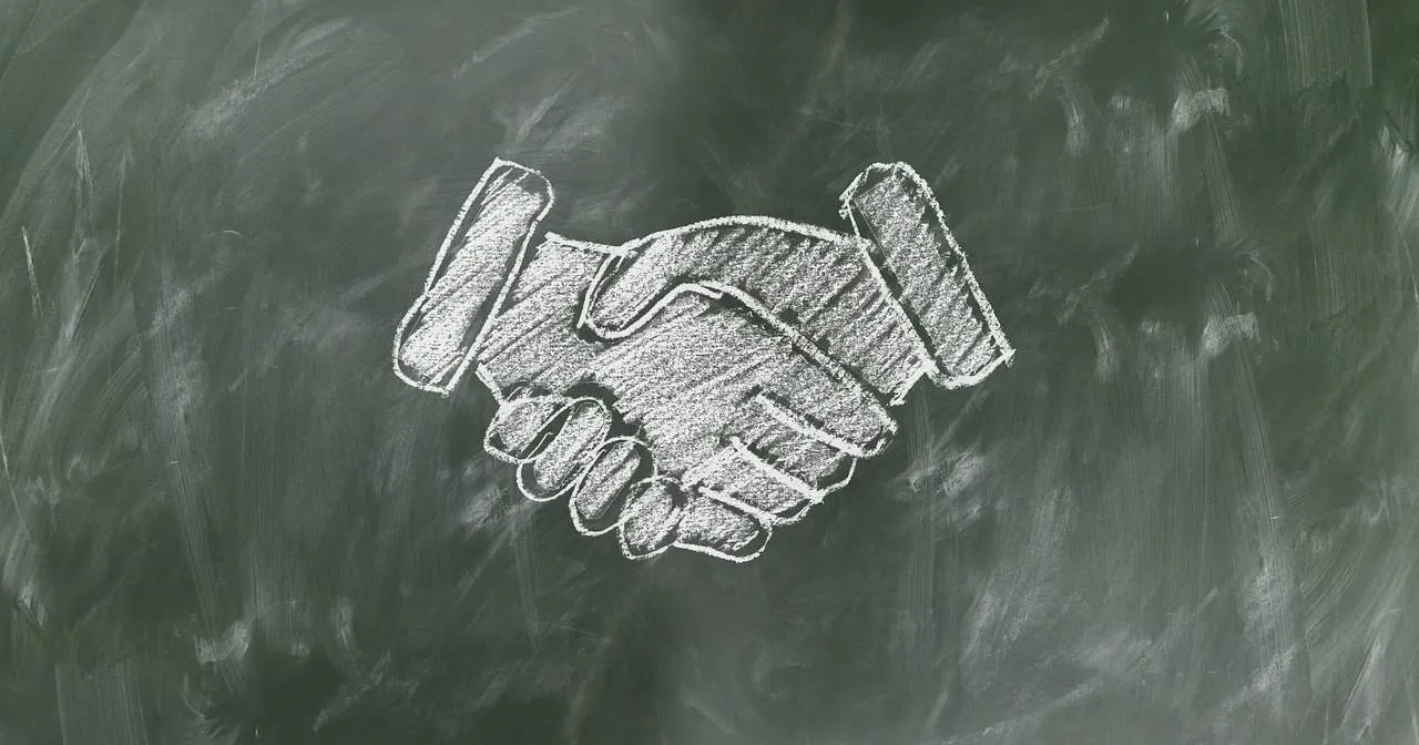 Handshake agreement symbol chalk drawing on blackboard, business partnership or collaboration concept, teamwork, trust, negot
