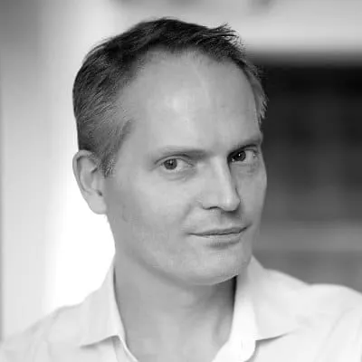 A professional black and white portrait of a man in business attire, showcasing confidence and expertise in the music industr