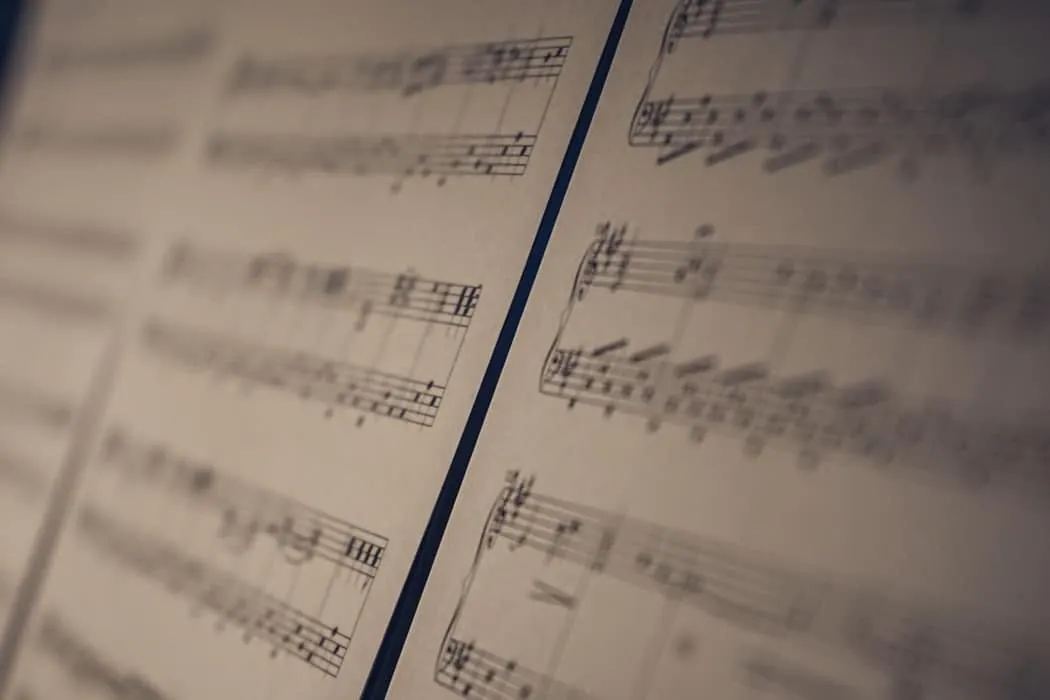 Vintage sheet music with musical notes and notation, close-up view, for music industry articles, music trends, and digital mu