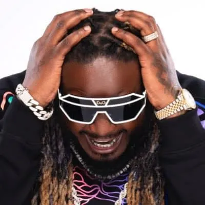 Stylish man wearing futuristic sunglasses and jewelry, adjusting his dreadlocks, expressive face, celebrity vibe, fashion-for